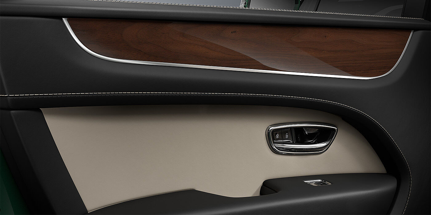 Bentley Berlin Bentley Bentayga SUV door interior detail in Portland and Beluga black hides with Crown Cut Walnut veneer