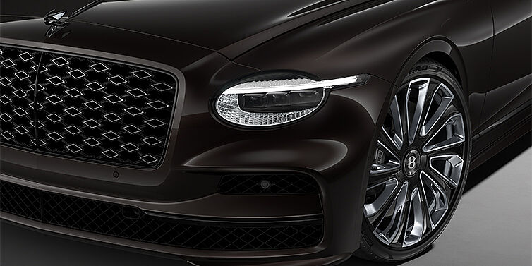 Bentley Berlin New Bentley Flying Spur Mulliner sedan head lamp against Havana brown paint with  22" Mulliner Black Painted & Polished wheel