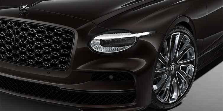 Bentley Berlin New Bentley Flying Spur Mulliner sedan head lamp against Havana brown paint with  22" Mulliner Black Painted & Polished wheel